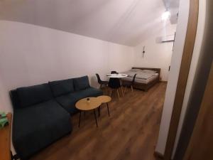a living room with a couch and tables and a bed at Apartament 12 in Zwardoń