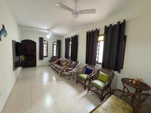 a living room with chairs and a couch at Casa com piscina in Bertioga