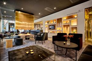 a lobby with couches and chairs and tables at KUST Hotell & SPA in Piteå