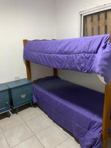 a bunk bed with purple sheets in a room at Casa de Lore in Necochea