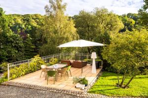 a patio with an umbrella and a table and chairs at Elbvilla Pirna mit Sauna und Kamin mit privatem Zugang zur Elbe in Pirna