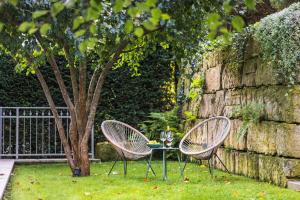 two chairs and a table next to a tree at Elbvilla Pirna mit Sauna und Kamin mit privatem Zugang zur Elbe in Pirna +39 photos