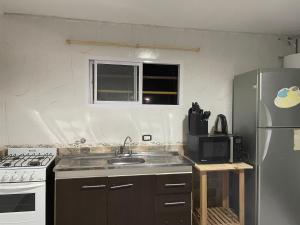 a kitchen with a sink and a refrigerator at Casa de Lore in Necochea