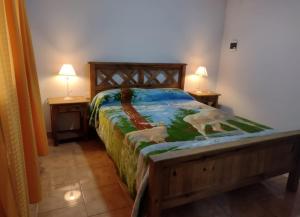 a bed in a bedroom with two lamps on two tables at Cabañas Los Dos Talas in Barrio Parque El Corcovado
