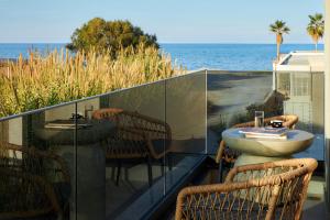 a balcony with chairs and a sink and the ocean at Diastar Luxury Suites NEW in Heraklio +75 photos