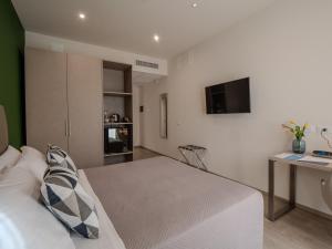 a bedroom with a bed and a desk and a television at Hotel Villa Maria in Crispiano