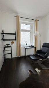 a living room with a chair and a table and a window at Paulus Living in Halle an der Saale