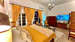a bedroom with a yellow bed and a tv at Resort Termas de Panimávida - Hotel & Spa in Panimávida