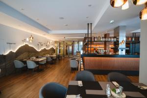 a restaurant with tables and chairs and a bar at Hotel Solisko in Štrbské Pleso