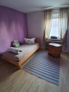 a bedroom with a bed and a purple wall at Ferienwohnung Elisa in Staig