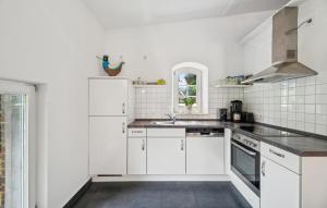 a white kitchen with white cabinets and a sink at Beautiful Apartment In Wingst in Wingst