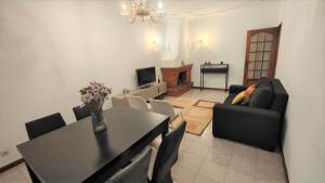 a living room with a table and chairs and a television at LUCINDA`S HOUSE in Braga