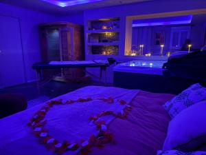 a purple room with a bed and a bath tub at Maison avec Spa Privatif, Jacuzzi et Sauna in Bailleval