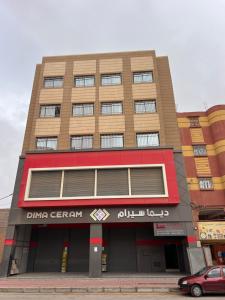 a tall building with a sign on the front of it at sahara house in Laayoune