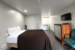 a bedroom with a bed and a television and a chair at 6 Rivers Motel Fortuna near Hwy 101 in Fortuna