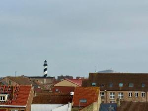 a view of a city with a lighthouse in the background at Sweet Harmonie in Grand-Fort-Philippe