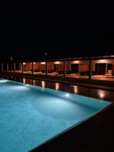 a swimming pool lit up at night at Herdade do Serra in Ervidel