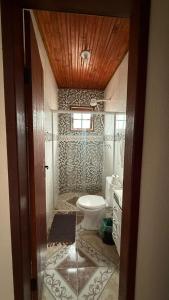 a bathroom with a toilet and a sink at Cantinho da Nara em Ibitipoca in Conceição da Ibitipoca