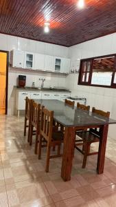 a kitchen with a wooden table and chairs in a room at Cantinho da Nara em Ibitipoca in Conceição da Ibitipoca