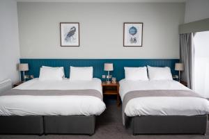a hotel room with two beds and a desk at The Caledonian Hotel in Leven