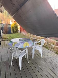 a table and two chairs on a deck at Zweizimmer-Häuschen im Schwarzwald in Schopfheim +7 photos