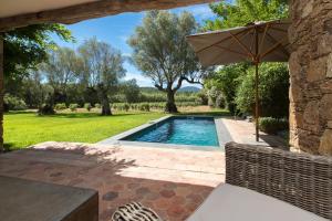 a swimming pool in a yard with an umbrella at Domaine Les Mésanges in Saint-Tropez +73 photos