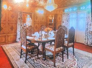 a dining room with a wooden table and chairs at Heevan in Srinagar
