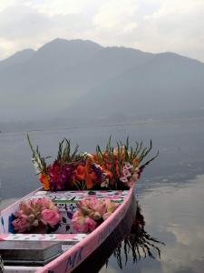 a boat with bouquets of flowers on the water at Heevan in Srinagar +2 photos