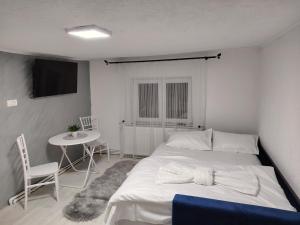 a bedroom with a large white bed and a table at Casa Aida in Peşteana +58 photos