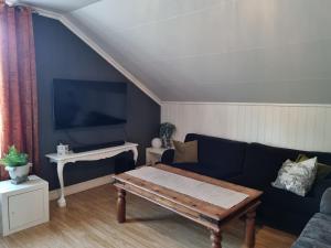 a living room with a couch and a table at Loftsleilighet in Vennesla