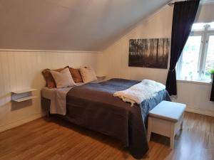 a bedroom with a large bed and a window at Loftsleilighet in Vennesla