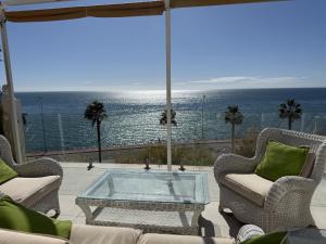 a patio with a table and chairs and the ocean at Mediterranean Escape with Panoramic Sea Views in Benalmádena