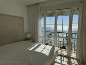 a bedroom with a bed and a large window at Mediterranean Escape with Panoramic Sea Views in Benalmádena +22 photos