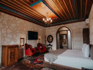 a bedroom with a bed and chairs in a room at Hikmet's House in Avanos