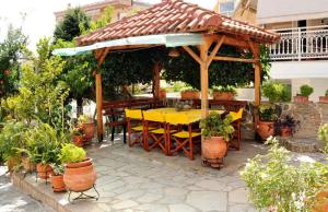 a wooden gazebo with a yellow table and chairs at Christina's Studio in Kalabaka