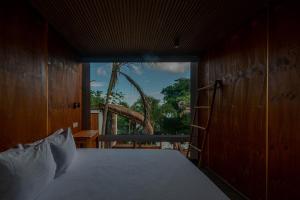 a bedroom with a bed and a large window at Tregua Bacalar in Bacalar