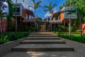 a stairway leading up to a building with palm trees at Tregua Bacalar in Bacalar
