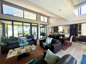 a living room with leather furniture and a table at House Vos in Hermanus