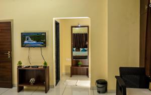 a living room with a tv and a mirror at The Shrine Hotel in Godarpura