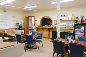 a restaurant with tables and chairs and a kitchen at Foothills Lodge & Cafe in Malone