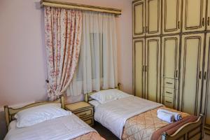 a bedroom with two beds and a large window at Soula's Traditional House in Kalabaka