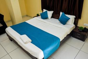 a large bed with blue and white pillows on it at The Shrine Hotel in Godarpura +3 photos