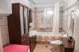 a bathroom with a tub and a toilet and a sink at Soula's Traditional House in Kalabaka
