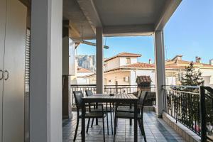 a patio with a table and chairs on a balcony at Soula's Traditional House in Kalabaka