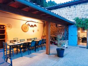 a patio with a table and chairs and a building at Brin d'Ardèche in Saint-Prix
