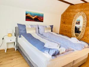 a large bed in a room with a mirror at Chalet Alpine in Kandersteg