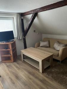 a living room with a couch and a coffee table at Penzion OK in Svoboda nad Úpou