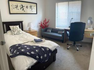 a bedroom with a bed and a desk and a chair at Point Cook Homestay House in Point Cook