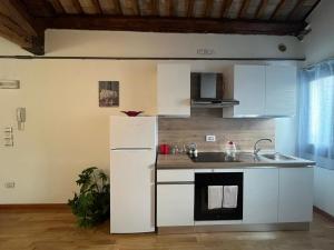 a kitchen with a white refrigerator and a sink at Osteria Locanda Veneta in Mirano