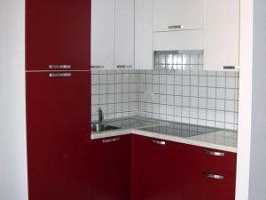 a kitchen with red cabinets and a sink at La Pergola Bilocale 6 - Cavo in Cavo